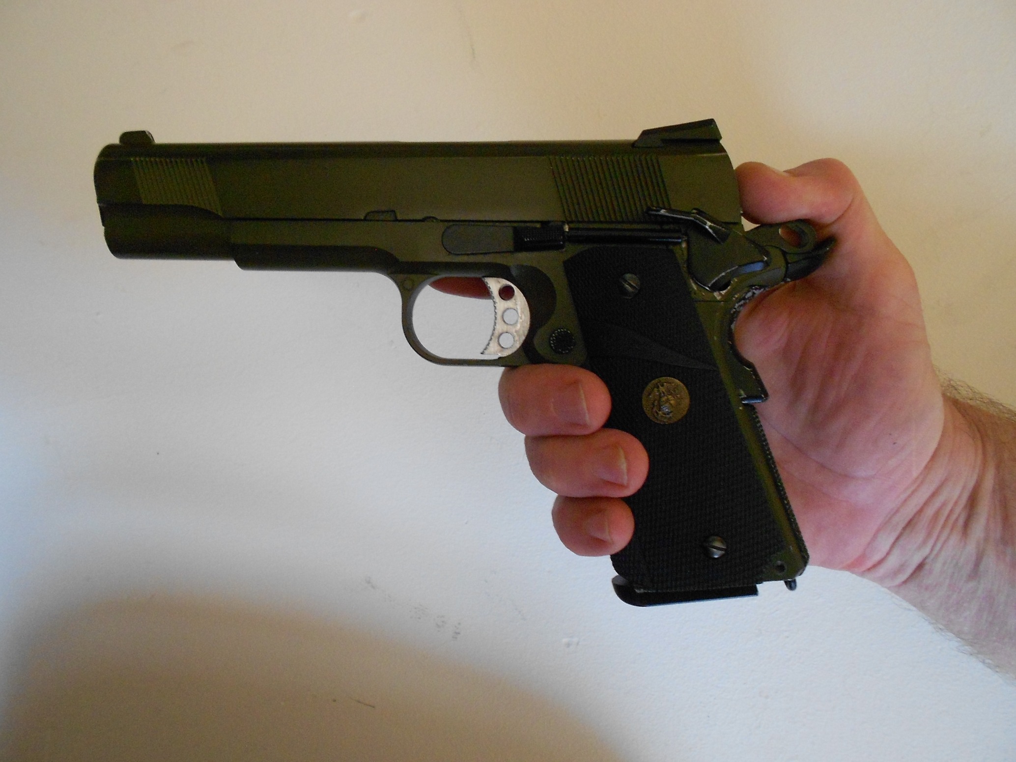 Correct hold ready to insert a 1911 pistol in Condition 1 "Cocked and Locked" into a holster. Finger out of the trigger guard, thumb on the hammer, safety catch on, grip safety not being depressed. The thumb is not removed from the hammer until the pistol is fully in the holster, the top break strap is secured and checked to be secured, and the safety catch has been checked to be still on. Condition 1 carry requires special vigilance.