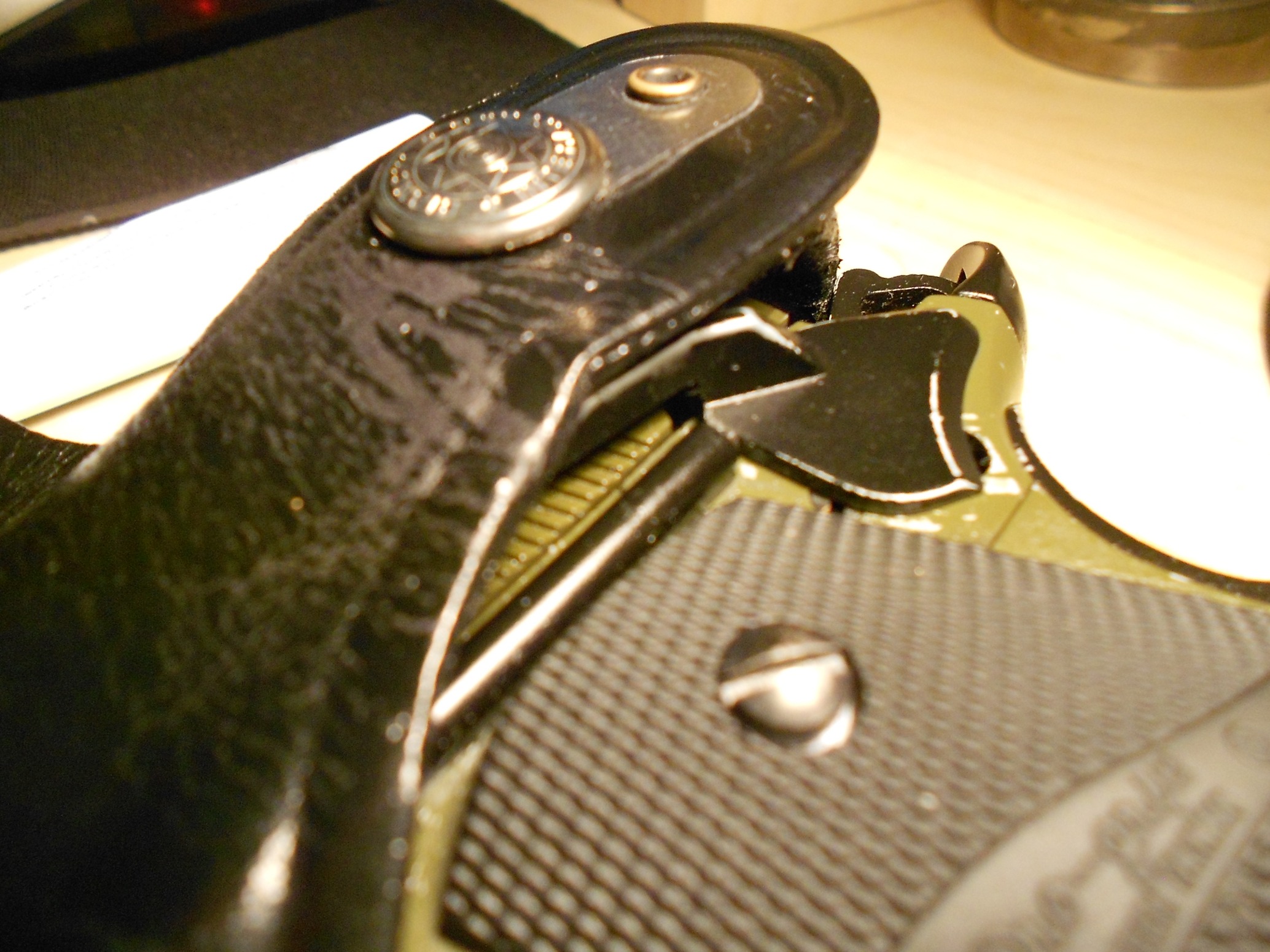 A close up of a 1911 pistol "cocked and locked" in a Bianchi Model 7 holster. As can be seen the top break strap sits against the safety catch tending to push it off. This seems to be an intentional design feature as the holster is designed for uncocked carry only.