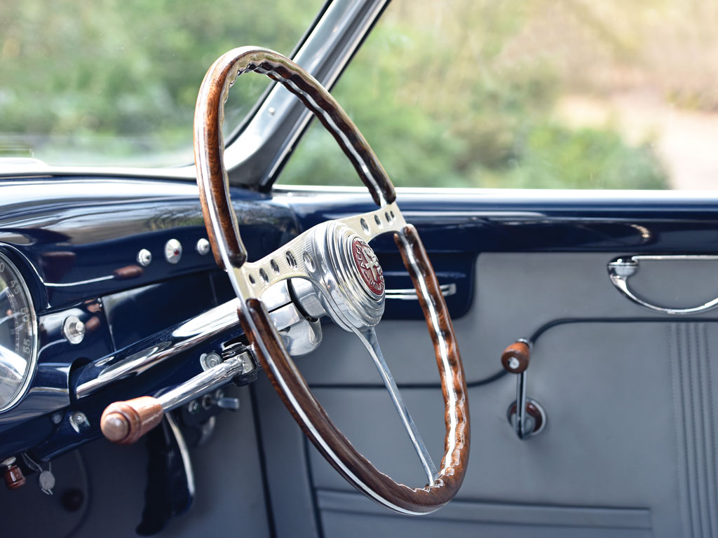 The cockpit is tasteful with a hint of art-deco. The wood on alloy steering wheel is a object of art of itself.