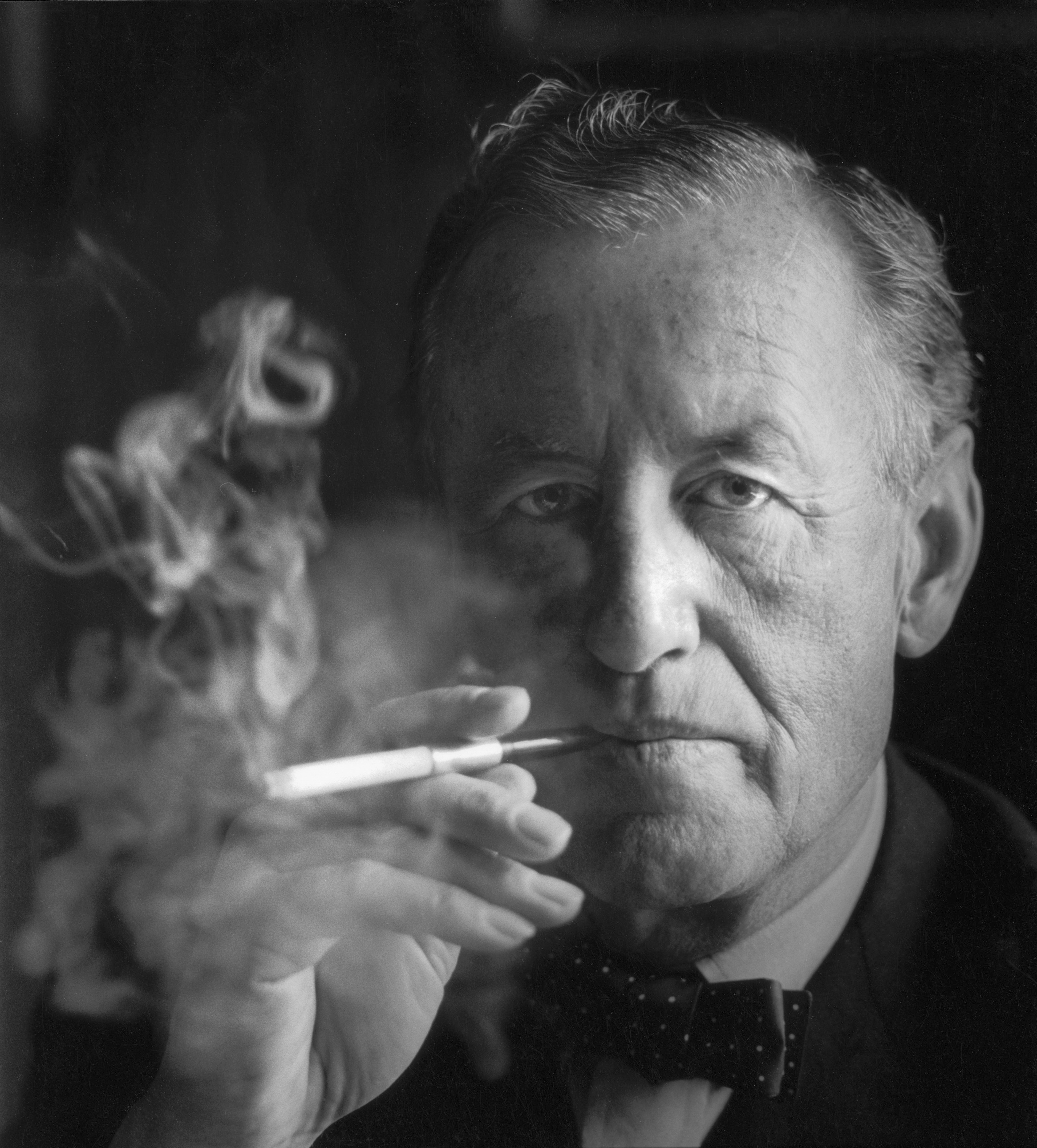 Ian Fleming (1908-1964), the creator of James Bond, creating a bit of a "smoke screen" symbolic of parts of his own secret service life, and that of 007, his fictional character,  (Photo by Horst Tappe/Hulton circa 1960. Archive/Getty Images)
