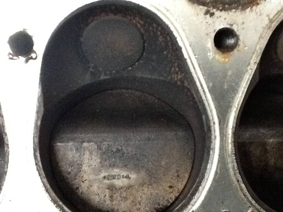 With the cylinder head removed the angled top of the piston and location of the exhaust valve can be seen. (Picture courtesy defendersource.com).
