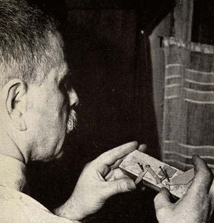 Mikhail Margolin working on a model trigger system using cardboard, nails and a wooden block. (Picture courtesy toyfj40.freeshell.org and a Guns Magazine's 1958 issue).