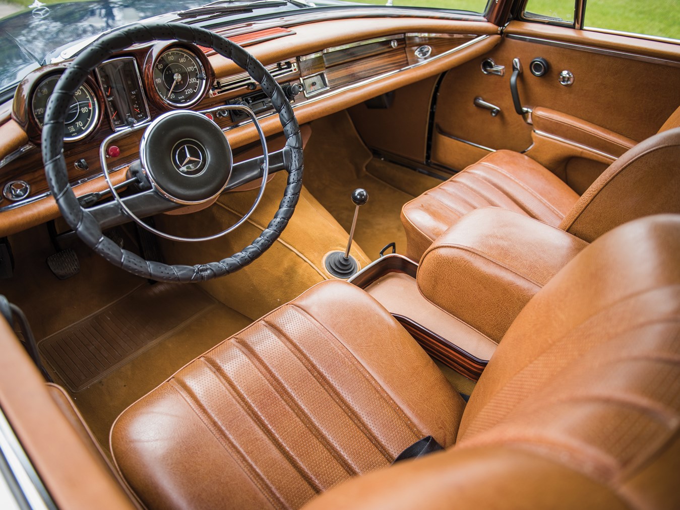 The manual transmission of this 1965 300 SE coupé makes it a luxurious driver's car with opulent mid-tan leather seats and wood veneer dashboard.