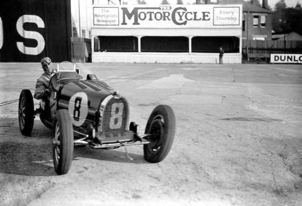 Earl Howe behind the wheel of his Bugatti Type 51. From the looks of the tire deflection he is having an absolutely spiffing time.