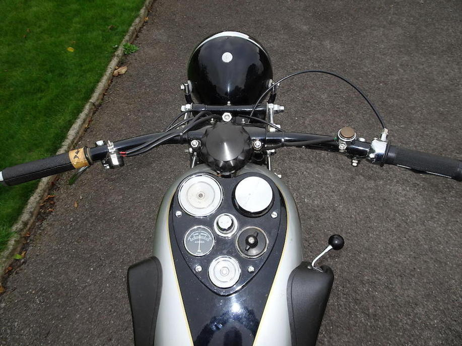 Rider's eye view of the New Hudson 500cc showing the instrumentation and right side mounted gear lever. The heart shape of the instrument panel on the tank perhaps tells us you have to have heart to ride a motorbike.